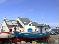 The outside of Bia Cois Farraige at Magheroarty pier showing boats near by